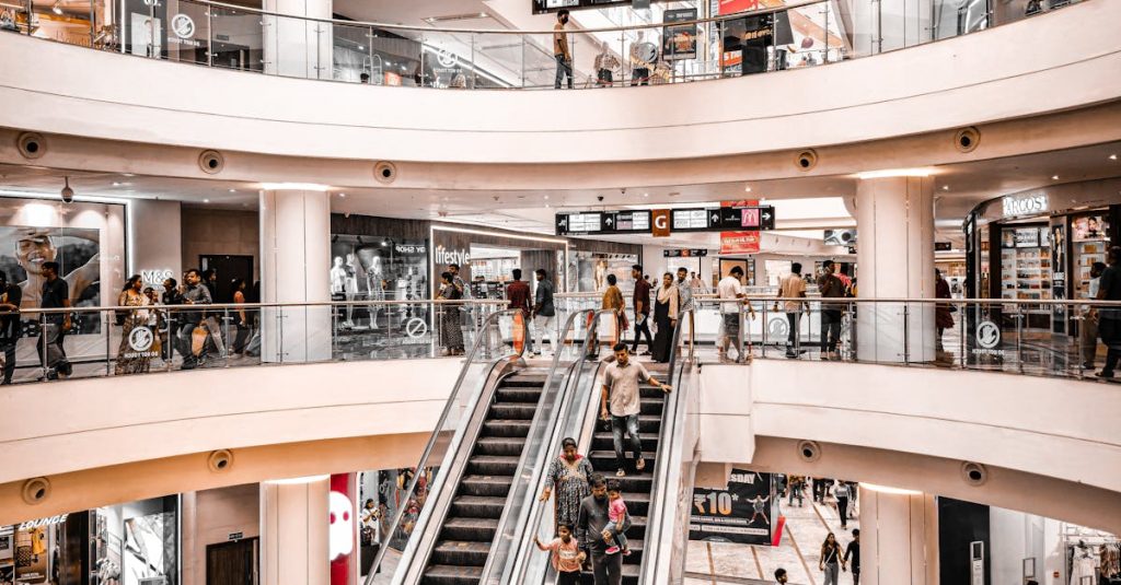 Modern shopping mall interior with vibrant atmosphere, featuring escalators and multiple levels of stores.